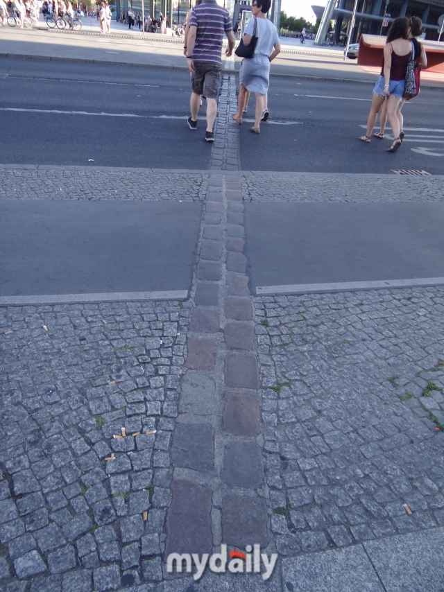 베를린 장벽이 철거된 후, 그 흔적이 이렇게 남았다. 사진 속 두 사람은 동베를린과 서베를린, 나아가 동독과 서독, 공산 진영과 자유 진영을 각각 걷고 있는 셈이다. 